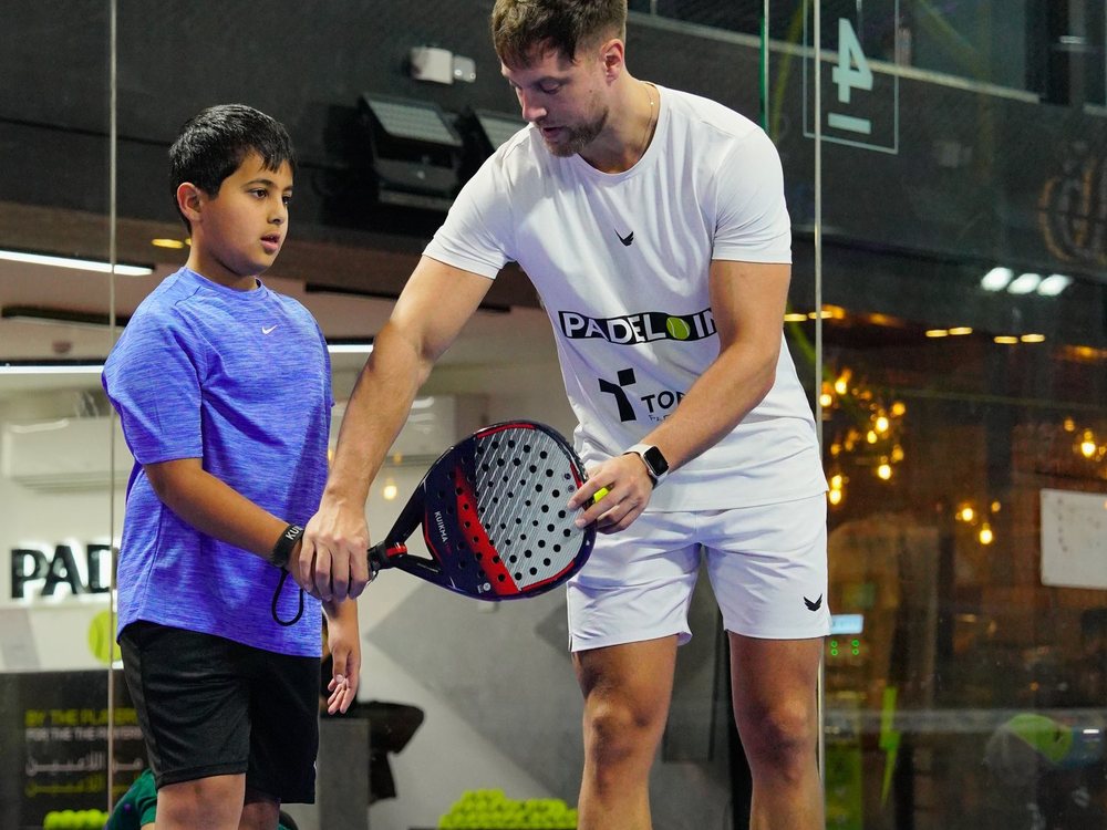 A Padel IN coach working one to one with a junior player