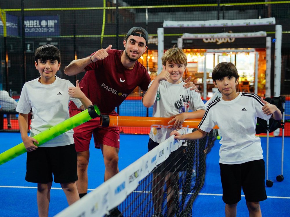 A junior squad gathered at the net with their coach